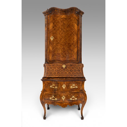 A German gilt-bronze mounted walnut and fruitwood bureau-cabinet. The parquetry-inlaid upper section enclosing a painted shelved interior over a conforming fall, and two banded drawers, with shaped apron, on angular cabriole legs. Circle of Abraham Roetgen, Rhineland, possibly Coblenz, 1750 circa.